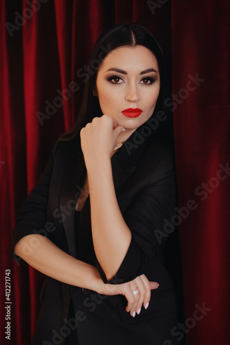 Photo of beautiful young brunette woman with red lips in a casual black clothes © Forewer