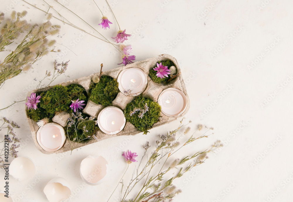 DIY Easter. Candlestick from an egg shell on a white background with flowers. Copy space DIY Easter. Candlestick from an egg shell on a white background with flowers. Copy space
