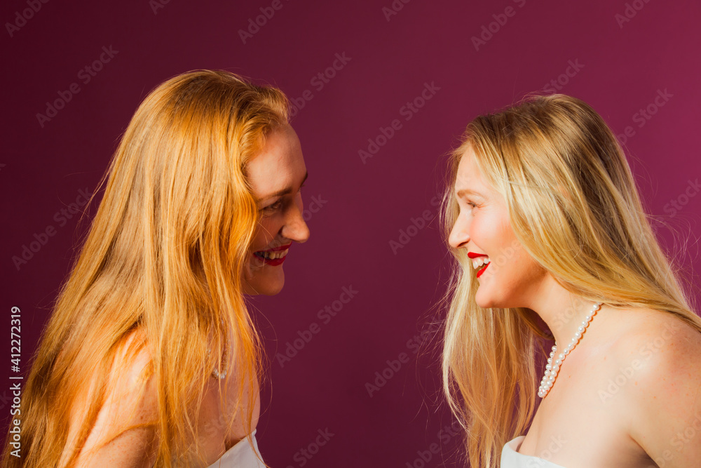 Two women standing opposite each other, touching by heads Two women standing opposite each other, touching by heads