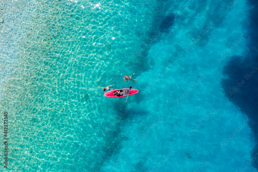Kayaking. Sup. Aerial view of floating board and people on blue sea at sunny day. Travel and active life image. Mediterranean sea.