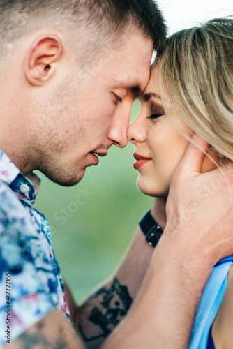 Fotografía blonde girl with loose hair in a light blue dress and a guy in the light of suns