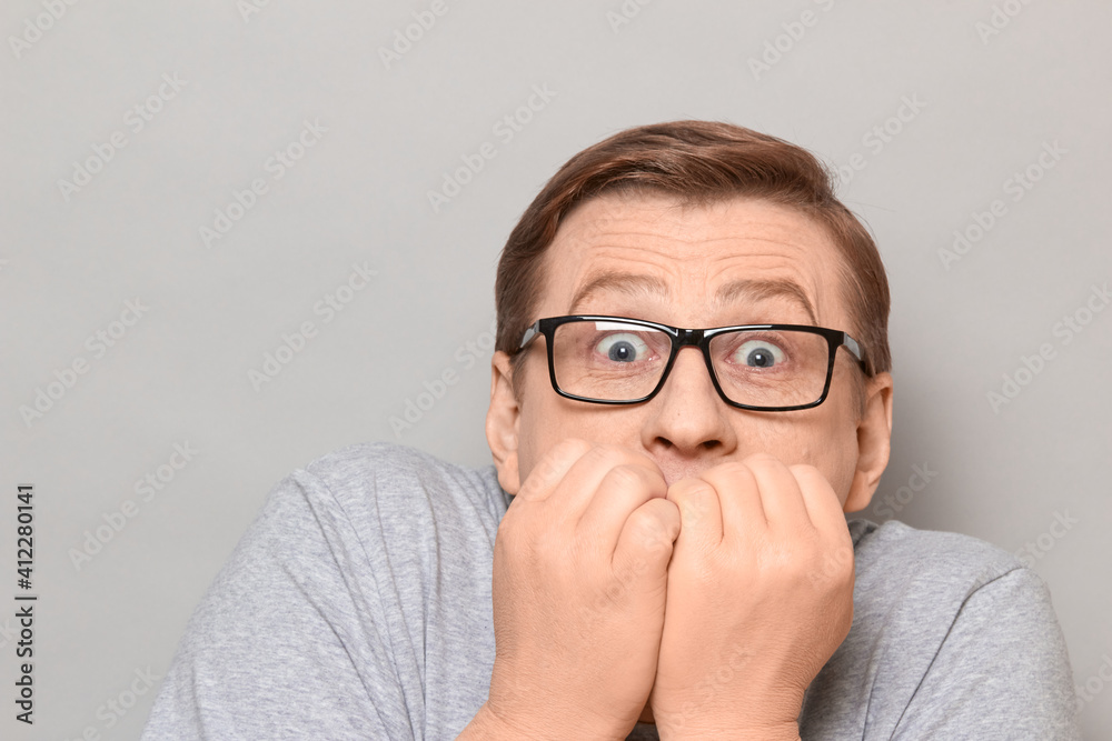 Portrait of shocked frightened man panicking and biting nails Portrait of shocked frightened man panicking and biting nails