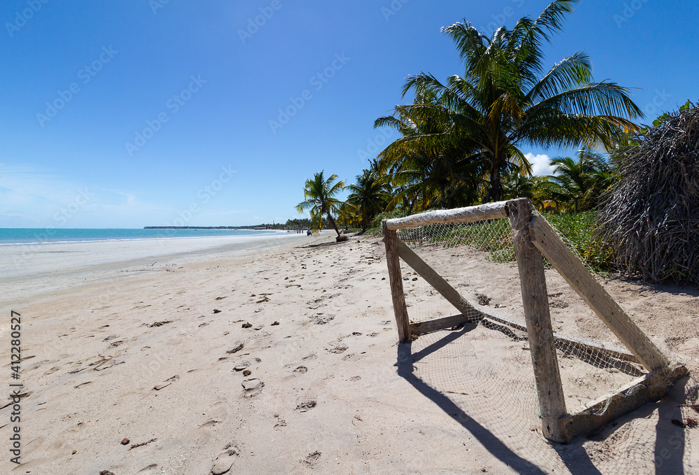 soccer goal made of wood on a beautiful beach with coconut trees and blue sky in the background soccer goal made of wood on a beautiful beach with coconut trees and blue sky in the background