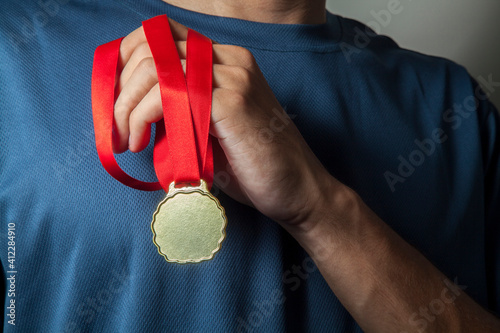 Athlete holding gold medal with his hands. Olympics concept. Medal concept.