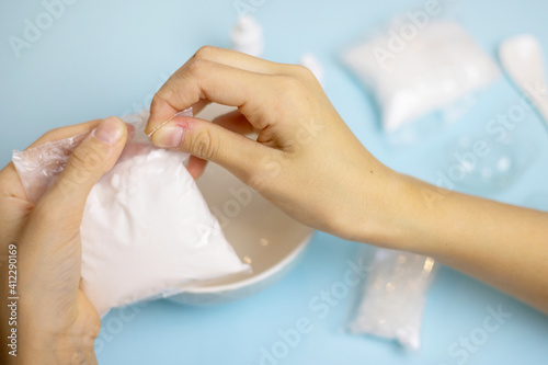 Wallpaper Mural a child makes a bath bomb from sea salt, citric acid, soda, dye and flavor on a blue background, instructions, step 1 Torontodigital.ca