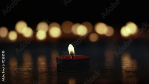 candle in night, a luminous candle in the dark on bokeh light-background.