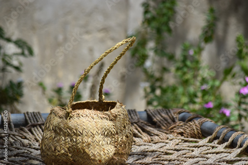 Human hand made dates tree box tool. palm leaf dry jar hanging on wood in garden, brown background culture thing Arabic style picture photo