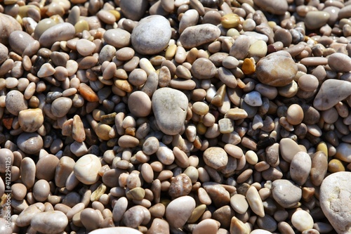 Round wet sea pebbles background, soft focus. Colorful smooth round pebbles sea texture backdrop 