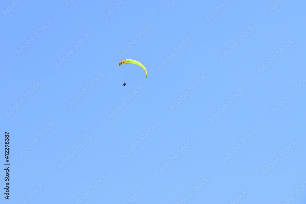 Paragliding in blue sky, soft focus, copy space. Paraglider flying in bright sunny day. Paragliding in blue sky, soft focus, copy space. Paraglider flying in bright sunny day.