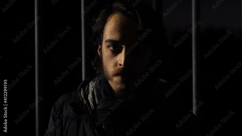 feeling trapped - young frightened man looks around suspiciously in the dark feeling trapped - young frightened man looks around suspiciously in the dark