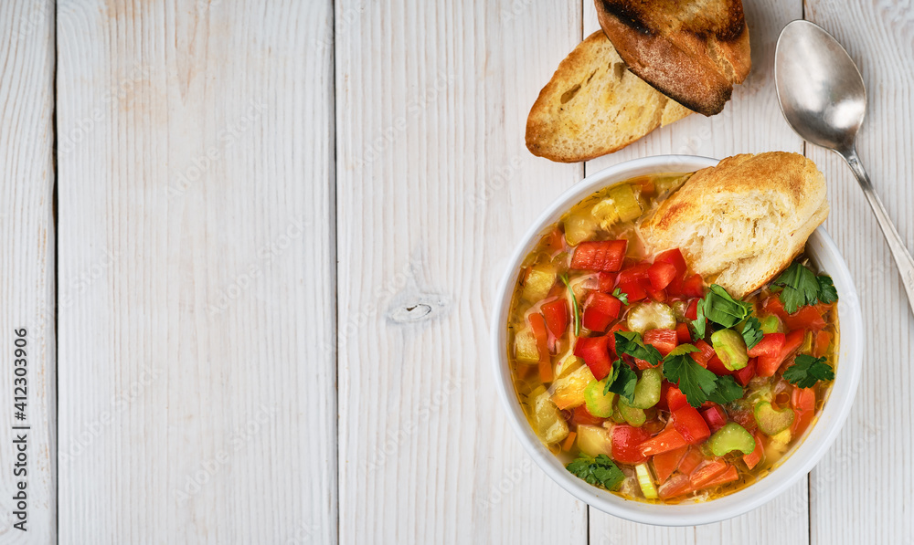Minestrone soup in white dish on white wooden table, top view. Italian soup with seasonal vegetables. The concept of delicious healthy vegetarian food. Diet idea nutrition. Flat lay with copy space Minestrone soup in white dish on white wooden table, top view. Italian soup with seasonal vegetables. The concept of delicious healthy vegetarian food. Diet idea nutrition. Flat lay with copy space