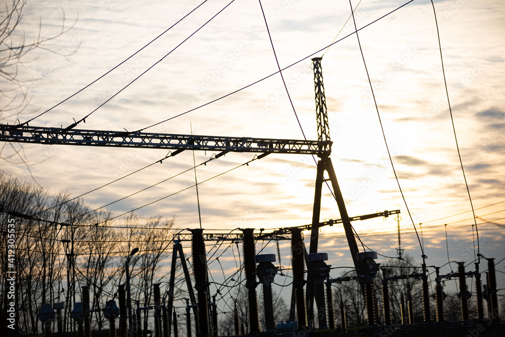High-power electricity transmission station at sunset with an installed lightning protection system.