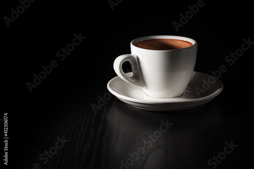 Obraz na płótnie Cup of coffee on black wood table. White porcelain cup on saucer. Copy space. w salonie