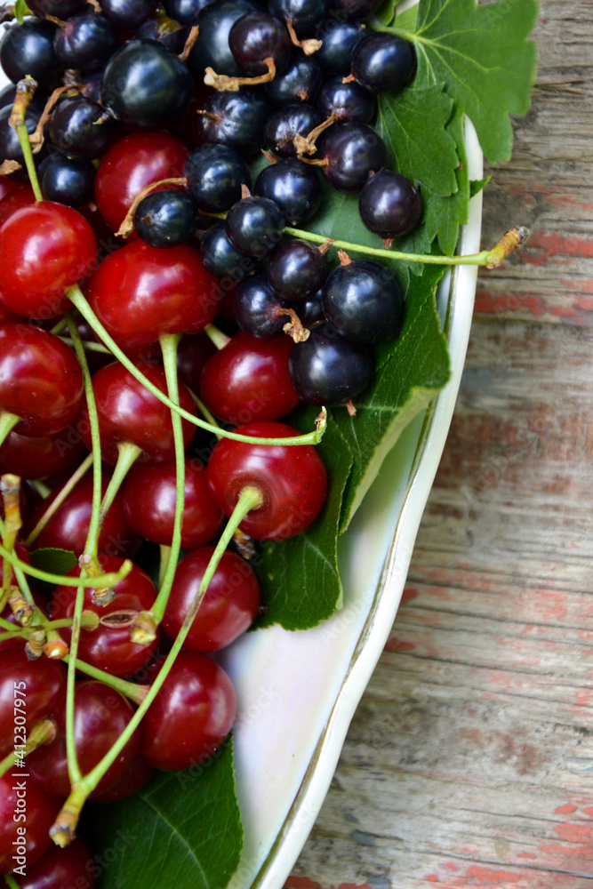 Berries organic harvest. Raspberry, black currant and cherry. Organic berries from village garden for jam, smoothie or desserts. Grunge wooden background. Berries organic harvest. Raspberry, black currant and cherry. Organic berries from village garden for jam, smoothie or desserts. Grunge wooden background.