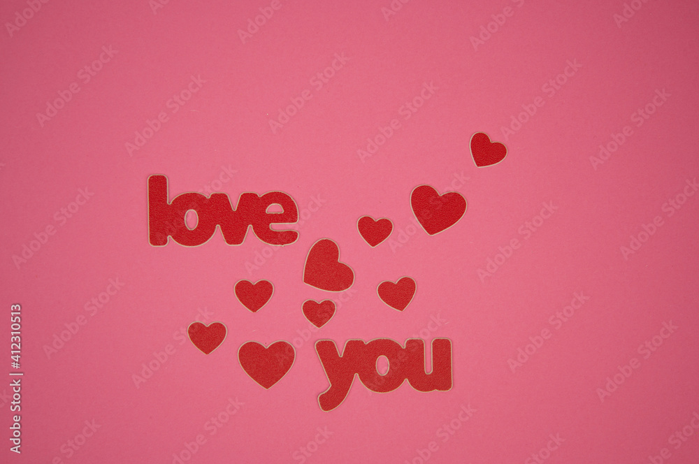Word Love you and red hearts on pink background.  Birthday or Valentines day greeting card