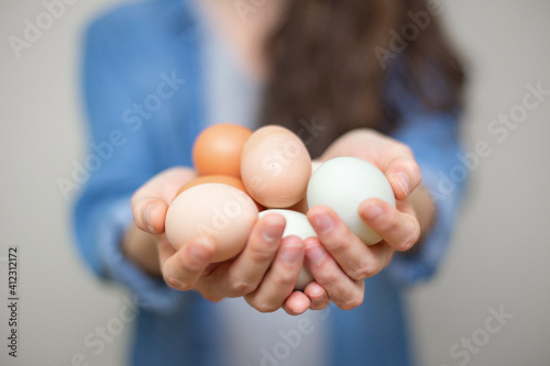 Young woman holding a group of farm fresh organic eggs. 