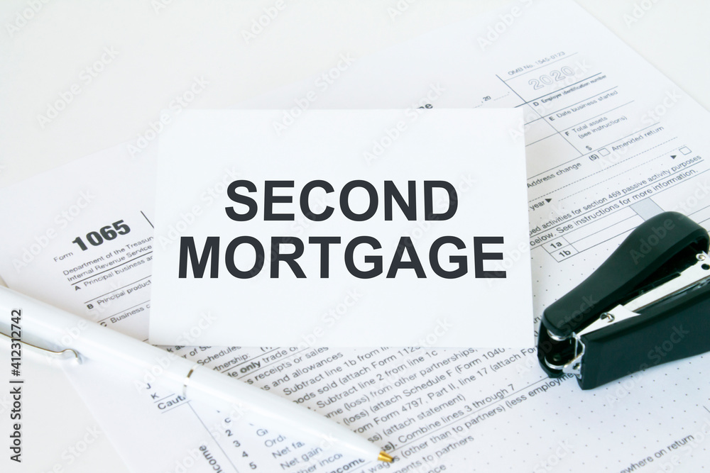 Text Second Mortgage on note paper with white pen and stapler Text Second Mortgage on note paper with white pen and stapler
