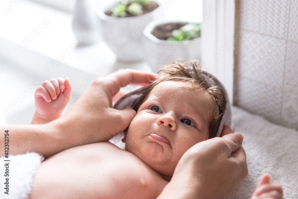 cute pouting baby being dressed by mum after a bath cute pouting baby being dressed by mum after a bath