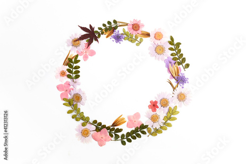 Wreath made from dry leaves and flowes on white background. Dry flowers frame. Flat lay.