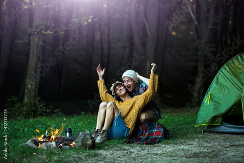 Romantic couple camping outdoors. Happy Man and woman on a romantic camping vacation.
