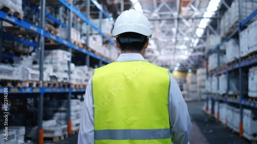 Follow footage of employees male warehouse worker engineer in hard hat working. walking through logistics center warehouse factory construction site logistics architect businessman man builder indoors