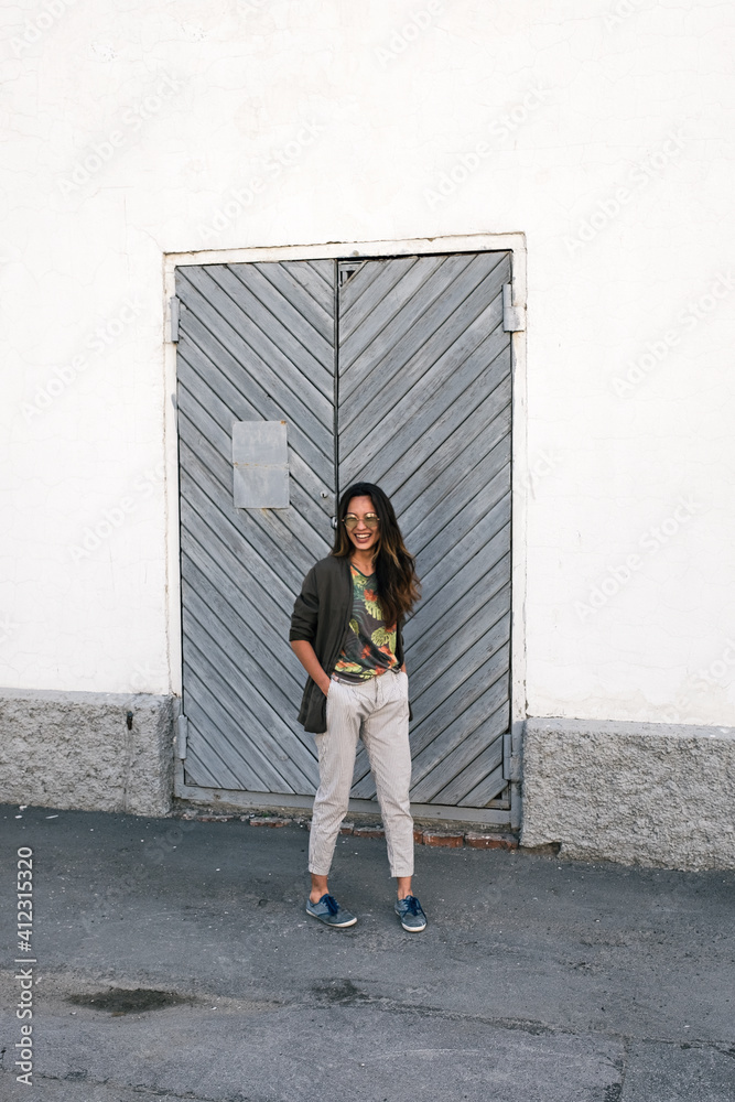 Laughing asian girl in sunglasses in the street with hands in pockets Laughing asian girl in sunglasses in the street with hands in pockets