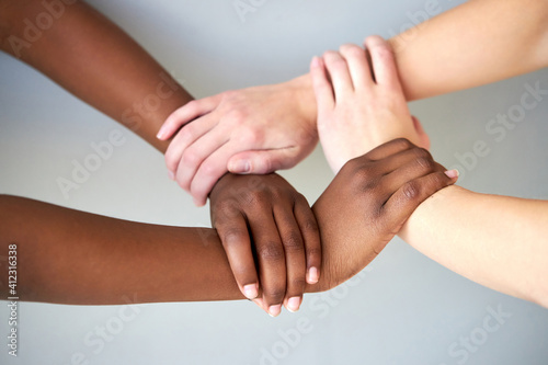 interracial human hands keeping in chains for friendship and love  concept of peace and unity against racism - multi ethnic couple holding hands isolated in studio