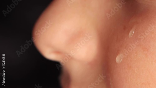 Wallpaper Mural Close-up of a kids cheek with a tear sliding down it. A tear slowly descends on the distressed face of a young boy, macro. High quality 4k footage Torontodigital.ca