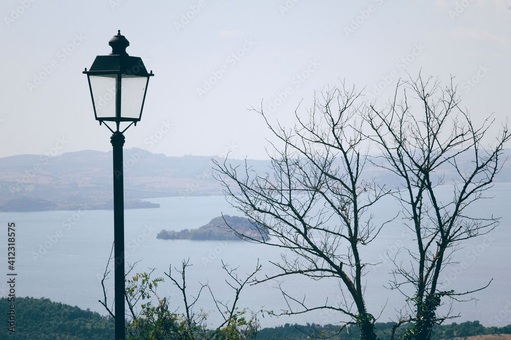 Italy, Lake Bolsena - view of the lake with street lamp and tree Italy, Lake Bolsena - view of the lake with street lamp and tree