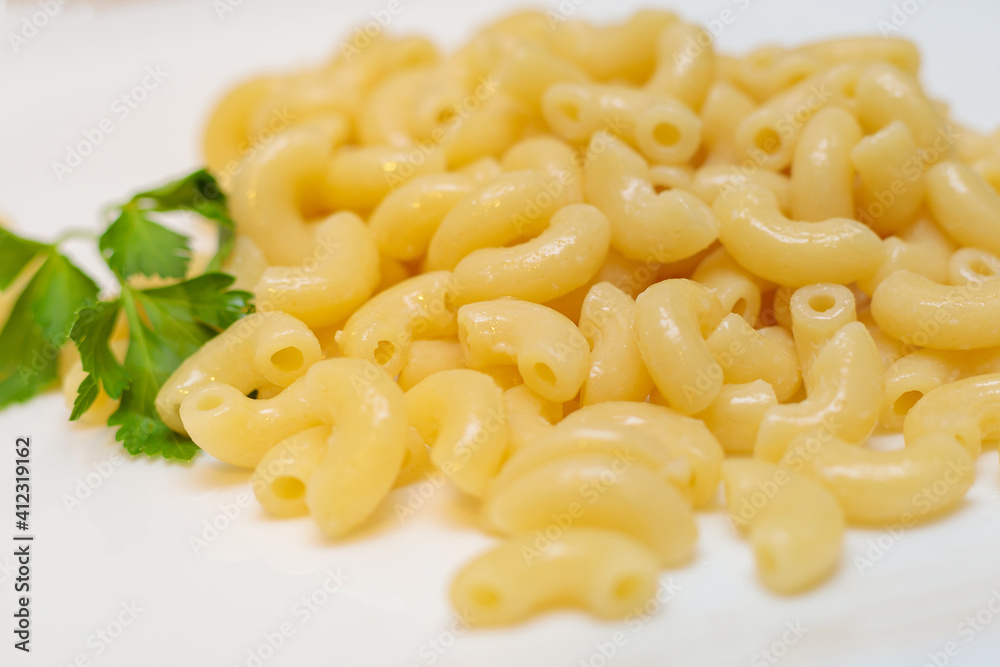 Boiled yellow pasta on a white plate. Boiled yellow pasta on a white plate.