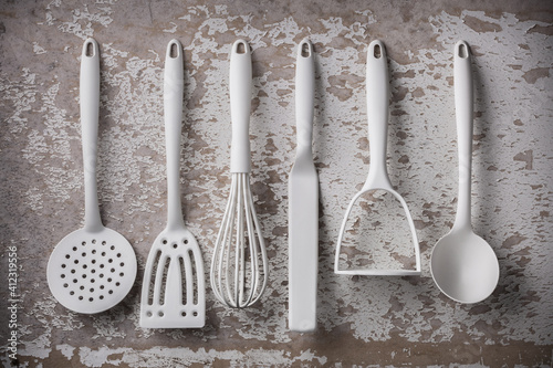 White kitchen cooking tools overhead arrangement on old gray wall background studio shot