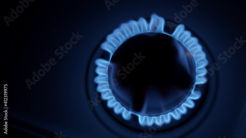 Kitchen burner turning on. Stove top burner igniting into a blue cooking flame. Natural gas inflammation, close up. photo