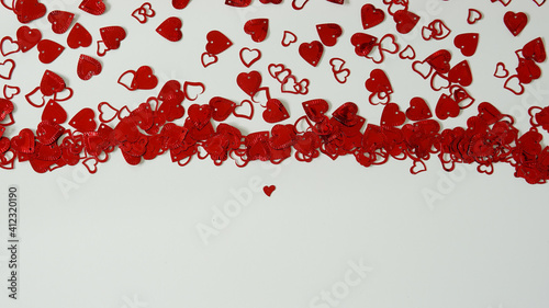 Fototapeta Naklejka Na Ścianę i Meble -  A red heart shaped confetti border with copy space.
