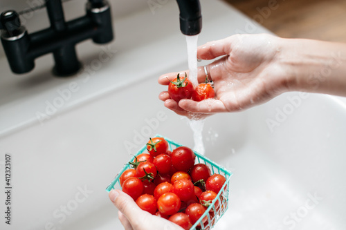 tomatoes being washed in a white sink