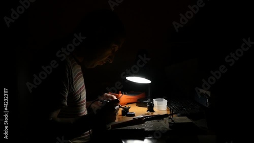 Medium plan a man is engaged in soldering small items
