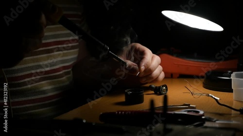Close-up of a man's hands working with a soldering iron