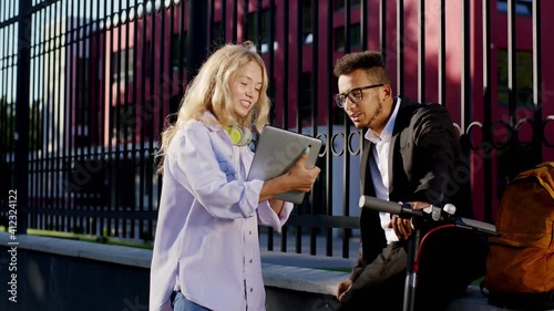 Wallpaper Mural After college course two students Afro American guy and young female with blonde hair have a discussing together lady holding digital tablet to showing something for her colleague Torontodigital.ca