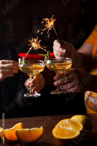 Sticker Celebrating new year eve 2022 with sparklers fireworks and drinking cocktails