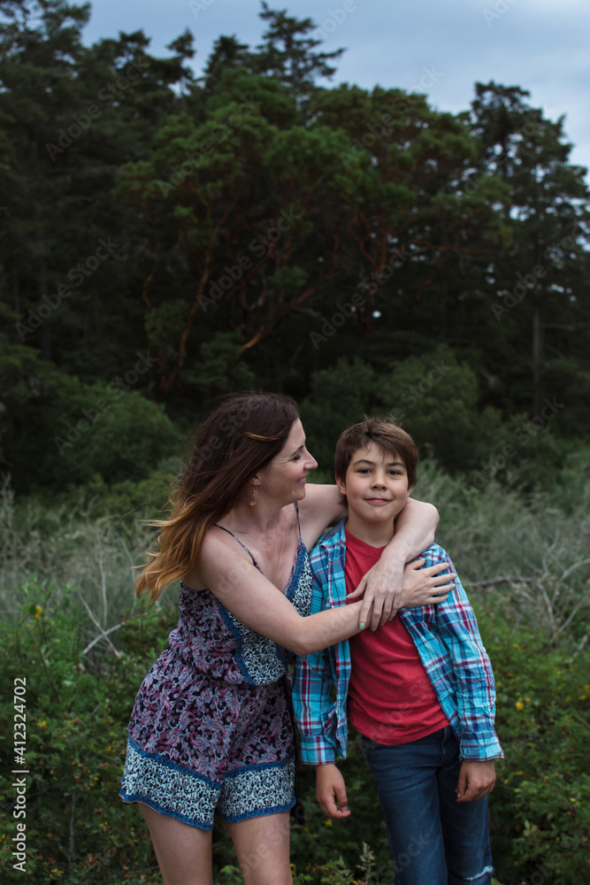 Mom and son spending time together outside in nature - hug Mom and son spending time together outside in nature - hug