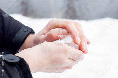 Obraz na płótnie Caucasian hands forming a snowball out of the fresh snow during winter in Europe. Enjoying cold snowy weather after Beast from the East climate change. w salonie