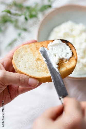 Woman spreading qatiq/cottage cheese on toast photo