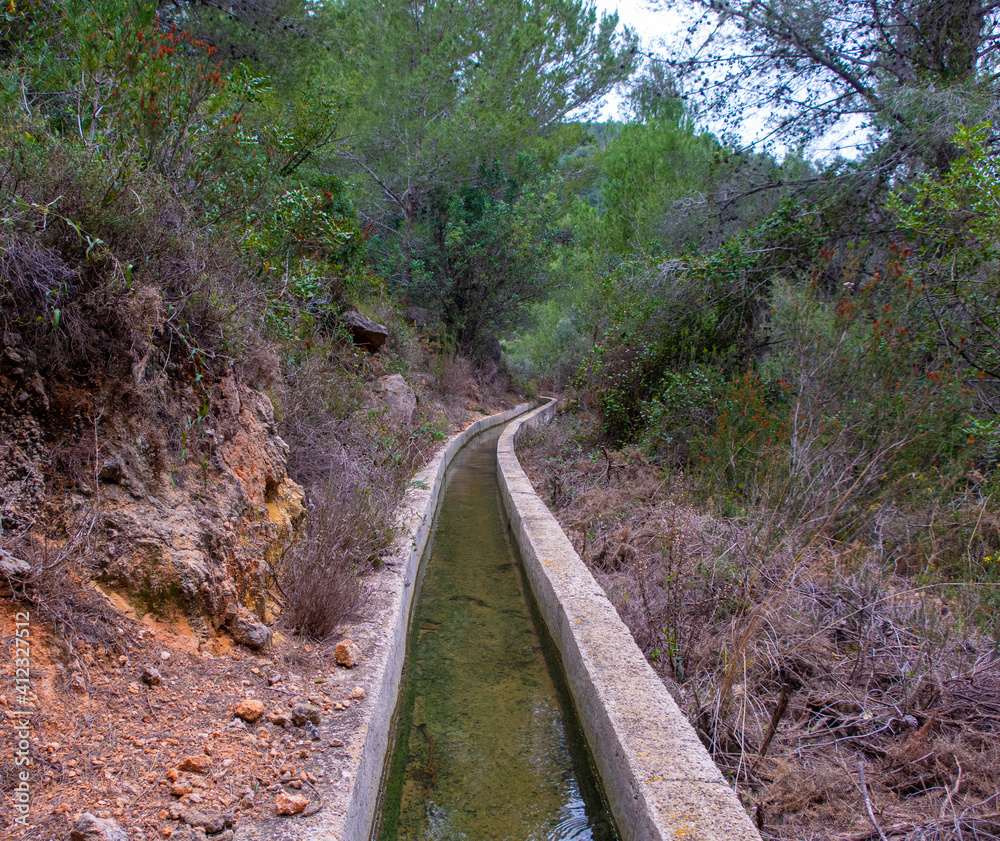 Irrigation ditch with water through the forest. Irrigation ditch with water through the forest.