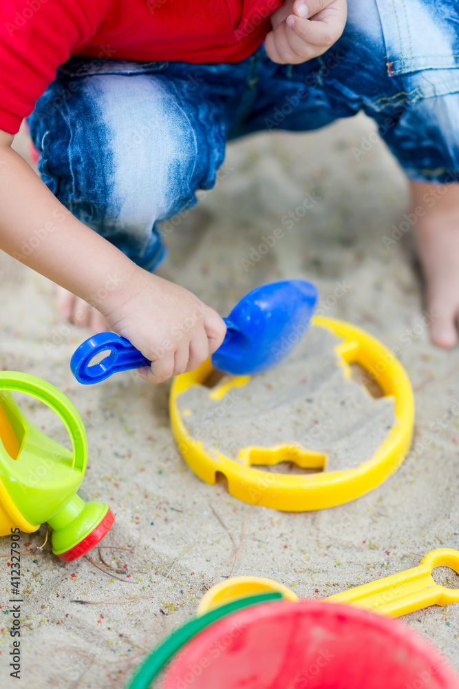 Child playing sand with toy tools at beach Child playing sand with toy tools at beach