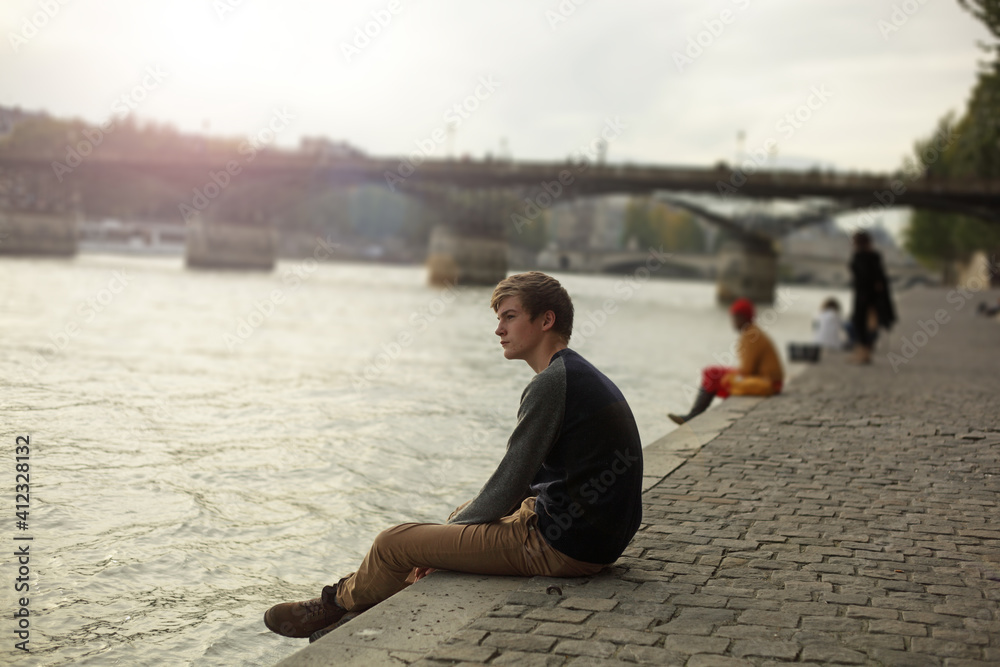 Boy sitting on the quay of the Seine Boy sitting on the quay of the Seine
