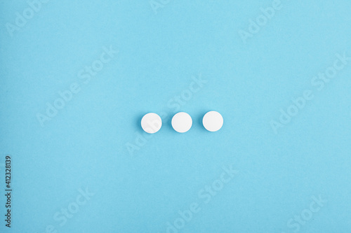 Closeup of white pills on a blue background. Heap of pills - medical background photo