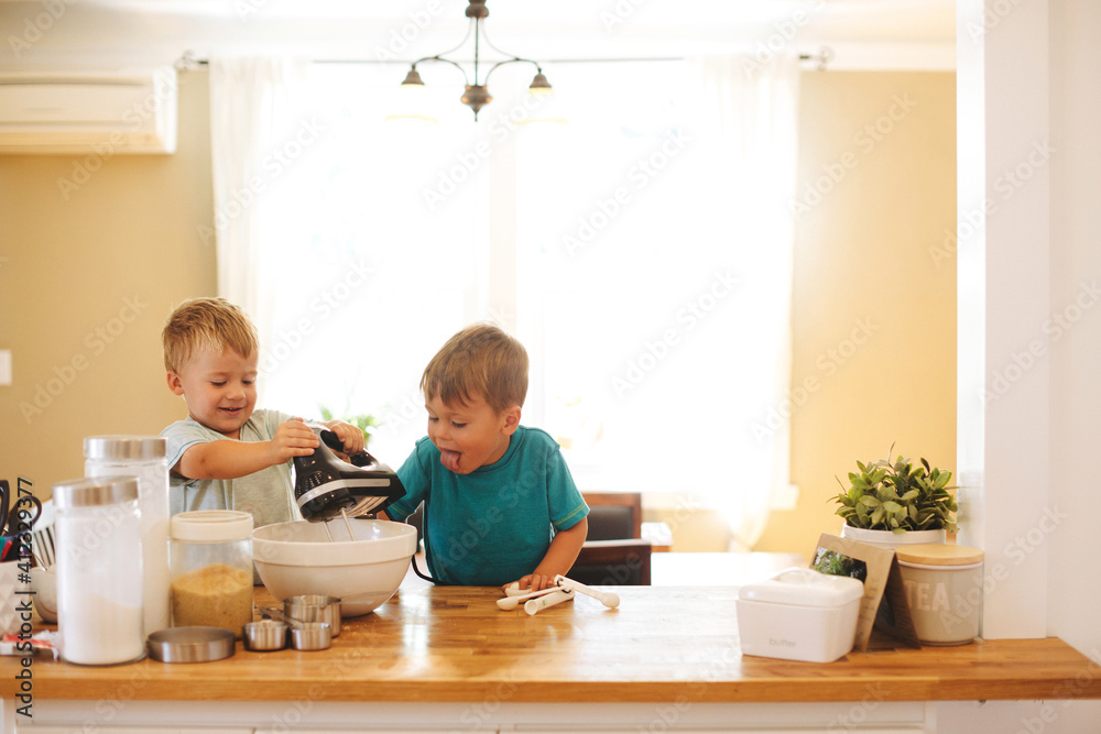 3 year old caucasian boys baking together at kitchen bar 3 year old caucasian boys baking together at kitchen bar