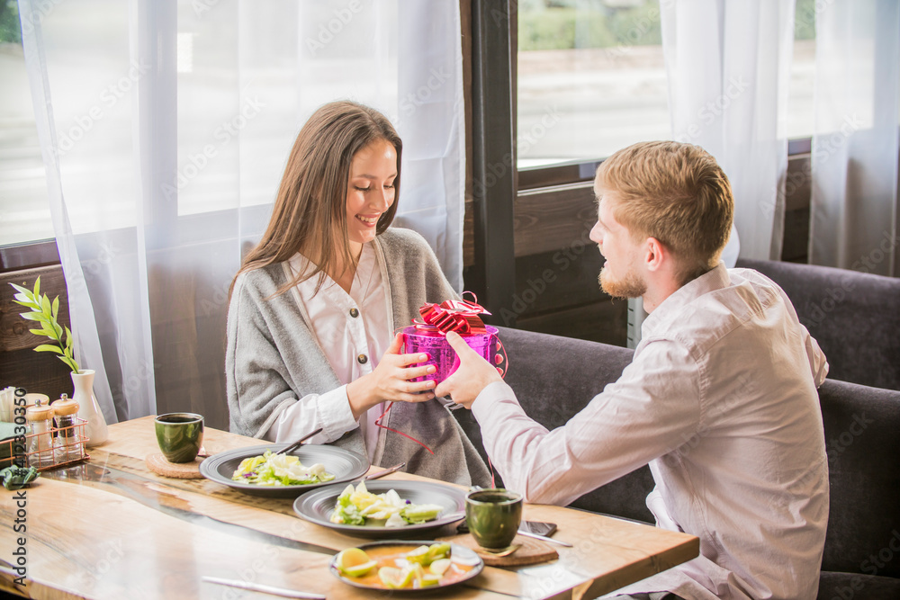 Happy man giving a gift to his girlfriend. Happy man giving a gift to his girlfriend.