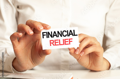 A woman in a white shirt holds a piece of paper with the text: FINANCIAL RELIEF. Business concept.