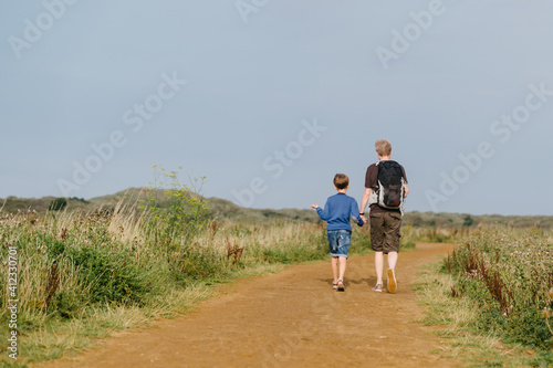 Father and son walking along a costal path