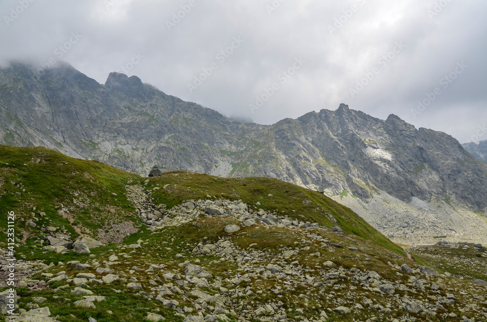 Beautiful sharp rocky peaks of mountain ranges under cloudy sky in the High Tatras, Slovakia